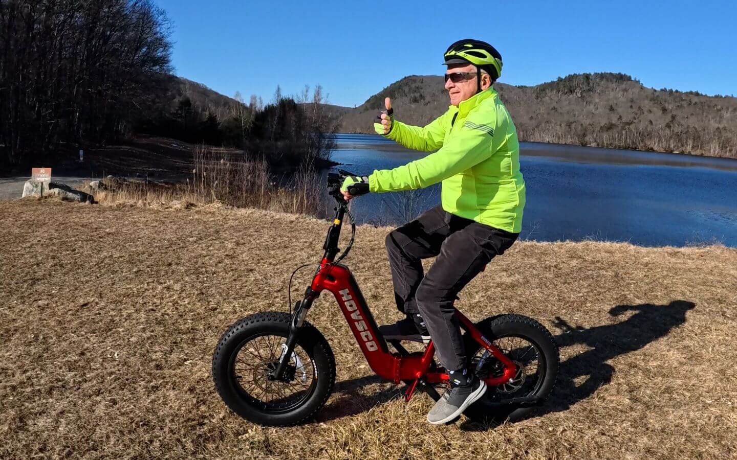 A-man-rides-hovbeta-folding-ebike-beside-a-lake