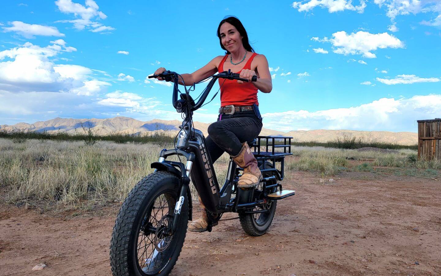 A-woman-rides-hovcart-through-a-vast-desert-landscape-under-a-clear-blue-sky